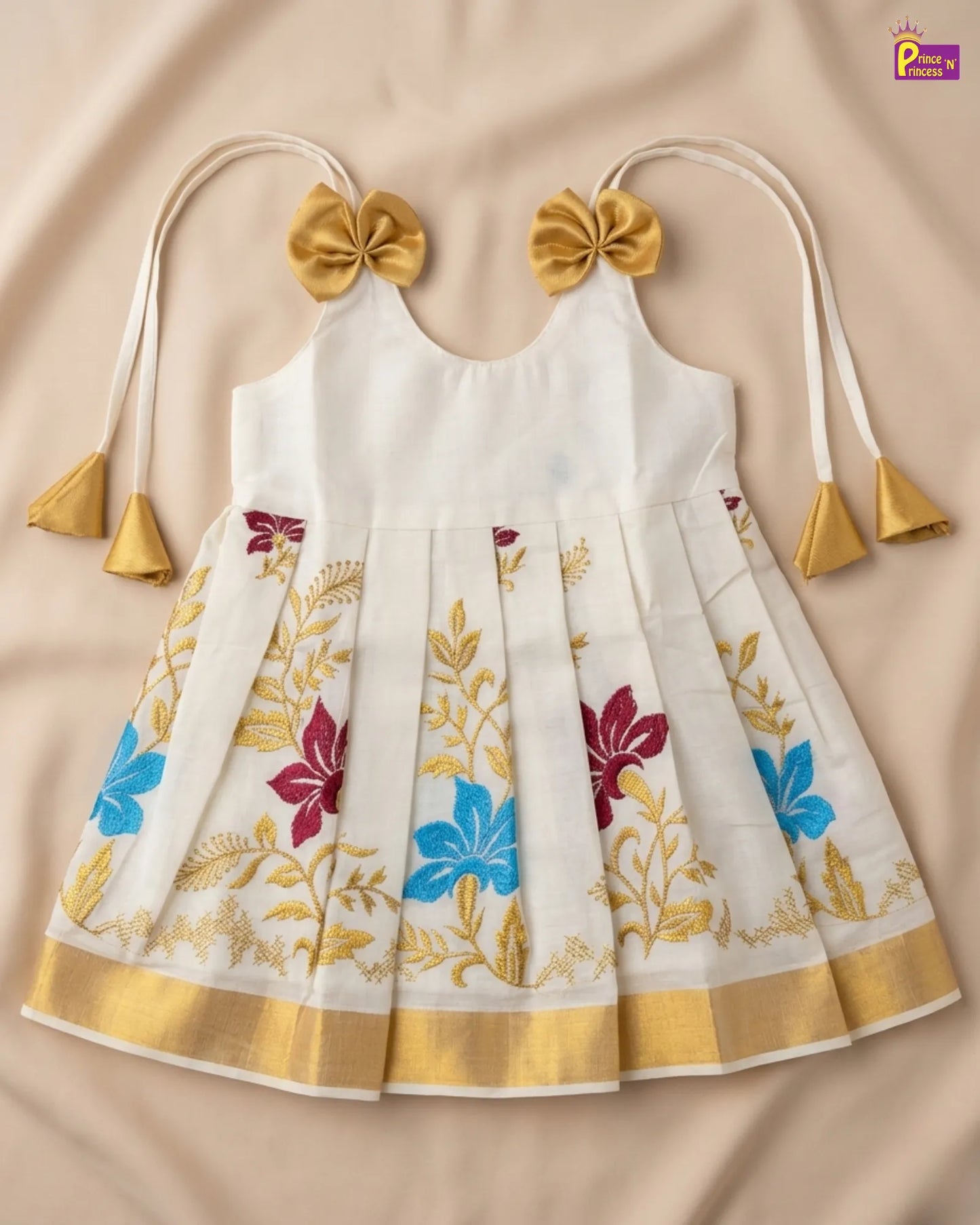 White dress with floral patterns and gold accents on a beige background