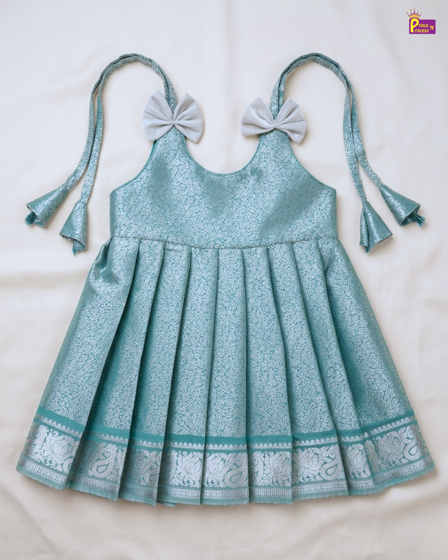 Teal dress with bow straps on a white background