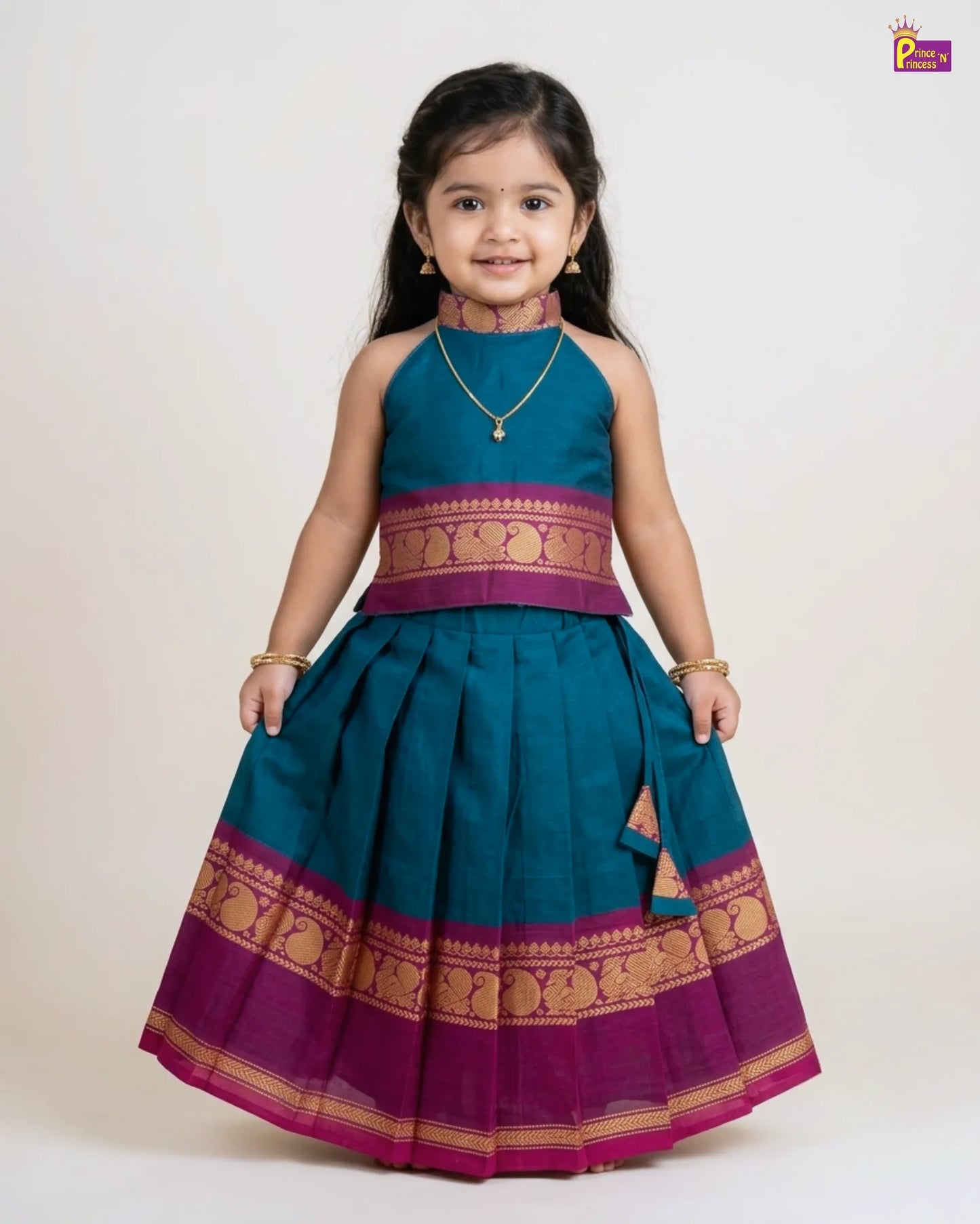 Young girl wearing a traditional teal and purple dress with gold accents on a white background