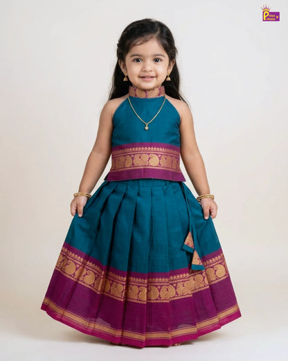 Young girl wearing a traditional teal and purple dress with gold accents on a white background
