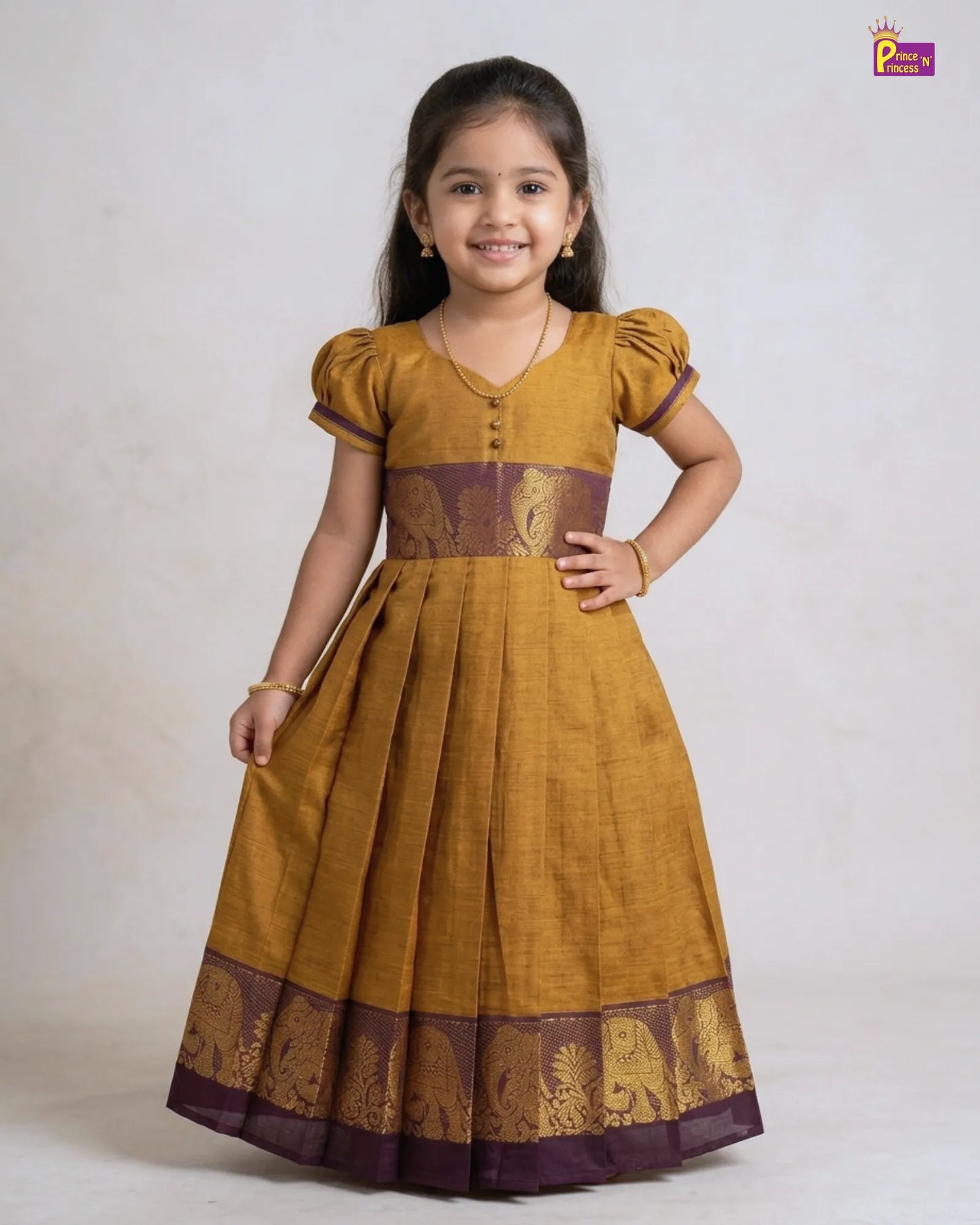 Young girl wearing a mustard yellow dress with brown accents on a white background