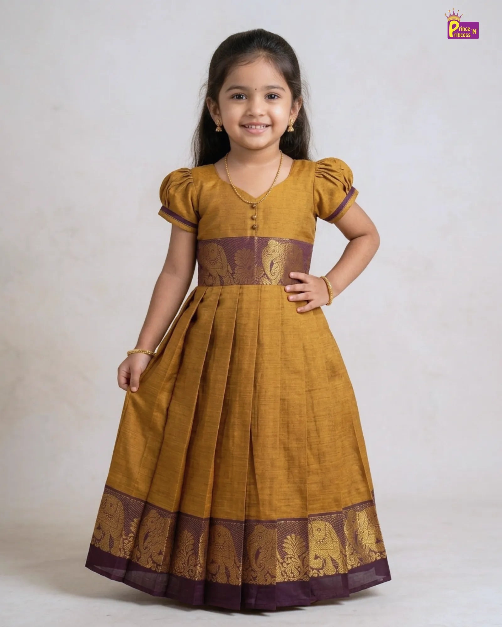 Young girl wearing a mustard yellow dress with brown accents on a white background