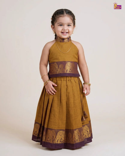 Young girl wearing a mustard yellow and brown traditional outfit on a white background