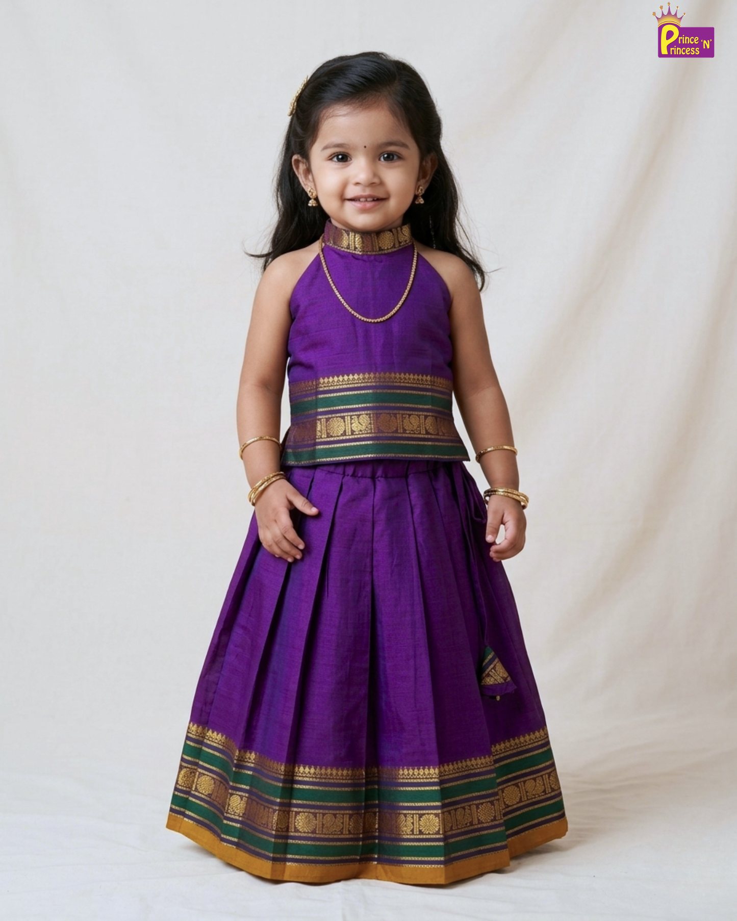 Young girl wearing a purple traditional outfit with gold and green accents on a white background