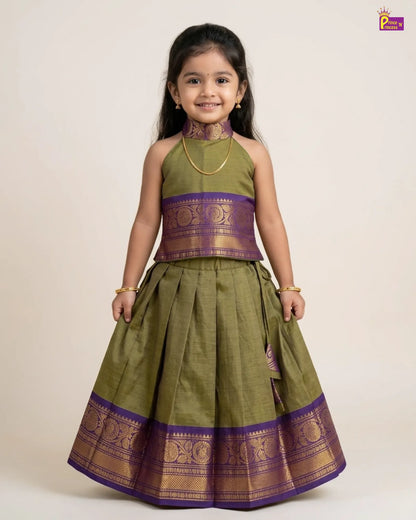 Young girl wearing a green and purple traditional outfit on a beige background