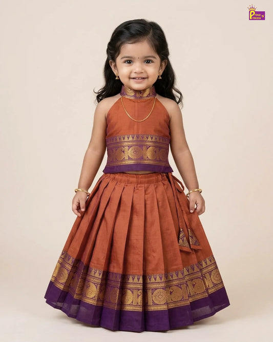 Young girl wearing a traditional outfit with a rust-colored top and skirt on a beige background
