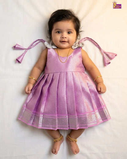 Baby wearing a pink dress with butterfly wings on a white background