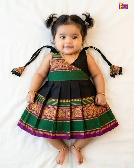 Child wearing a traditional outfit with green, purple, and black colors on a white background