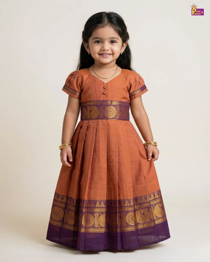 Young girl wearing a traditional orange and purple dress with gold patterns on a white background
