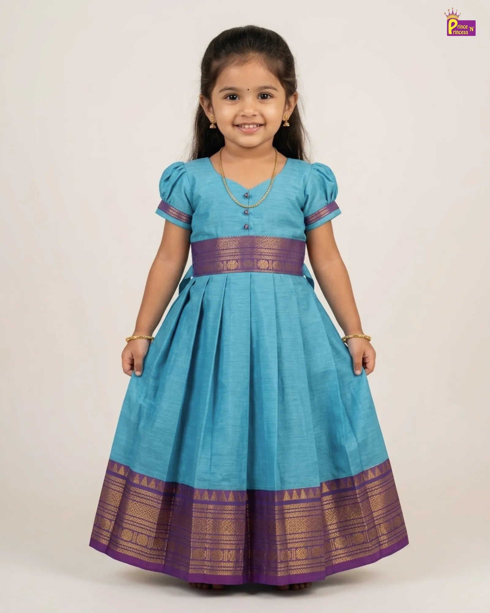 Young girl wearing a blue dress with purple accents on a white background