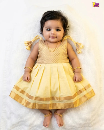 Baby wearing a yellow dress with a white background