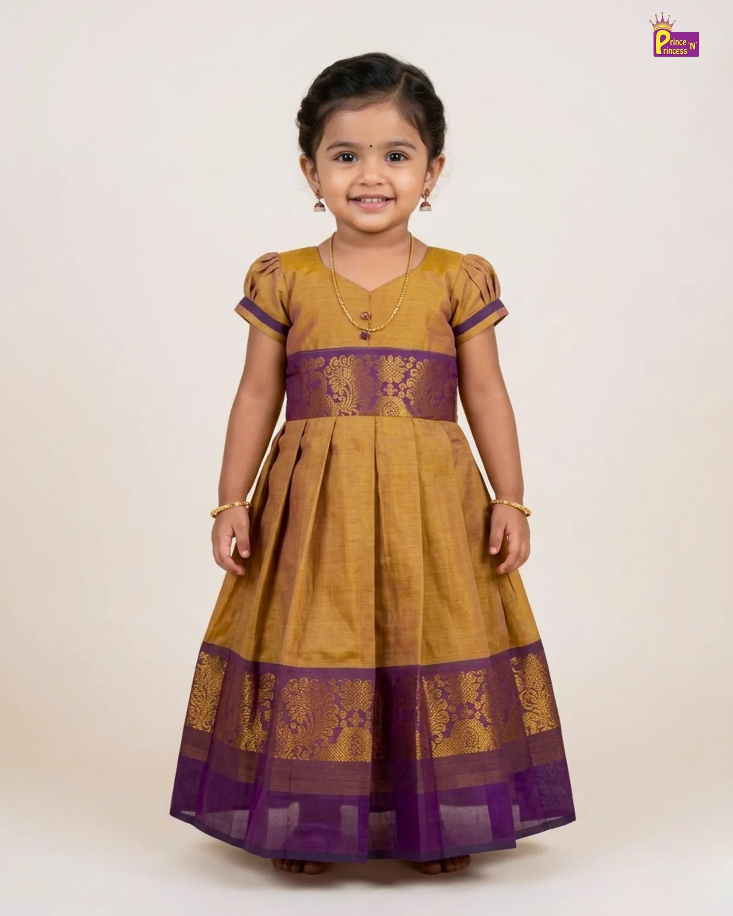 Young girl wearing a mustard yellow and purple traditional dress on a white background