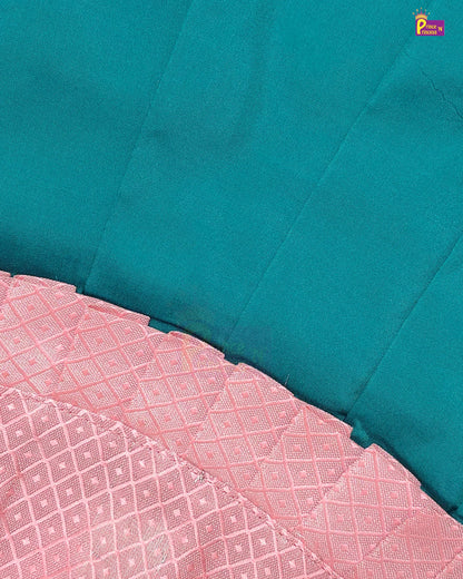 A close-up of a teal blue fabric with a folded pink patterned fabric showing its woven texture.