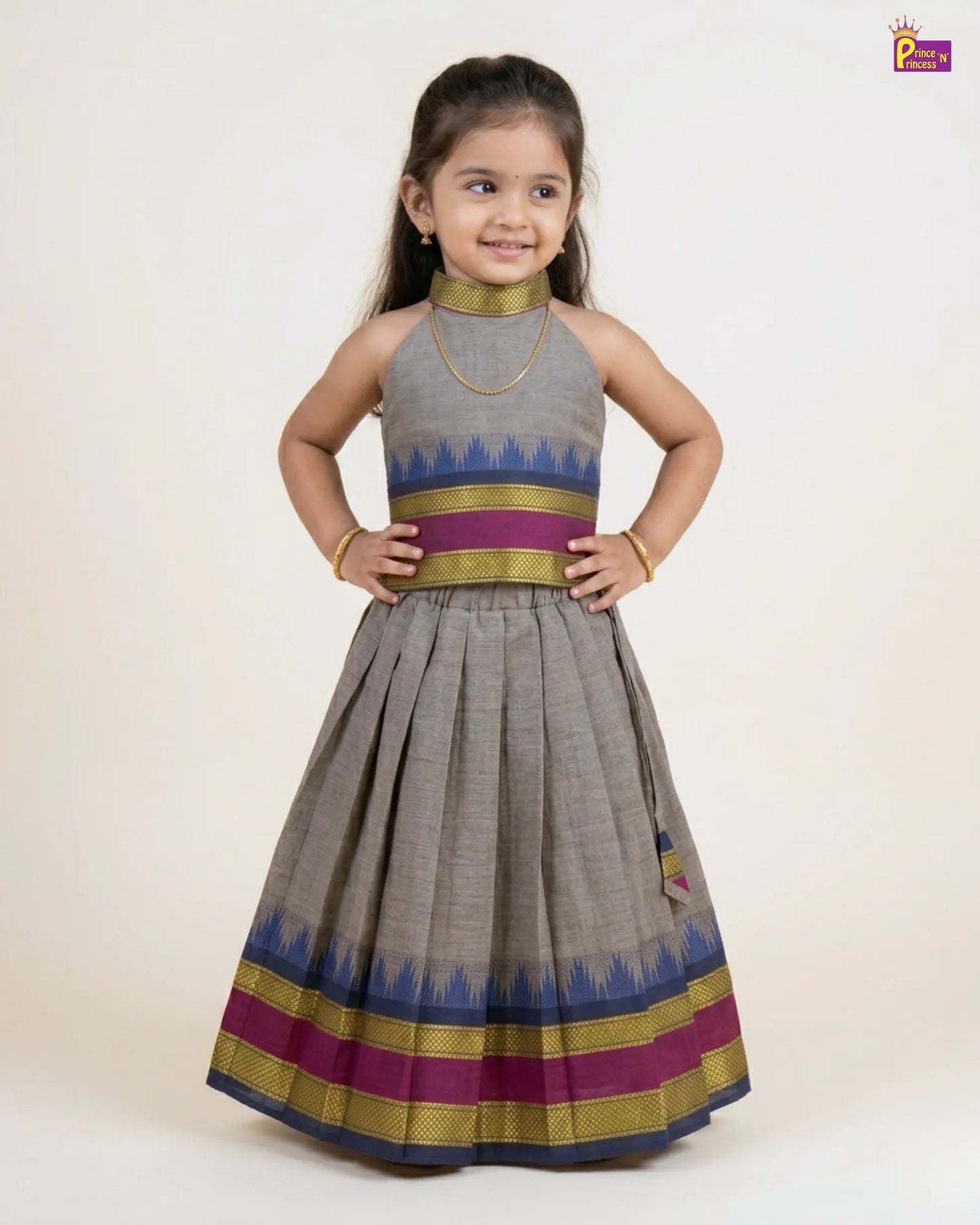Young girl wearing a traditional outfit with a gray dress and colorful patterns on a white background