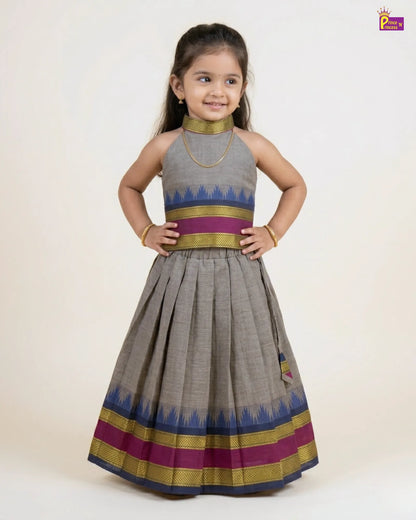 Young girl wearing a traditional outfit with a gray dress and colorful patterns on a white background