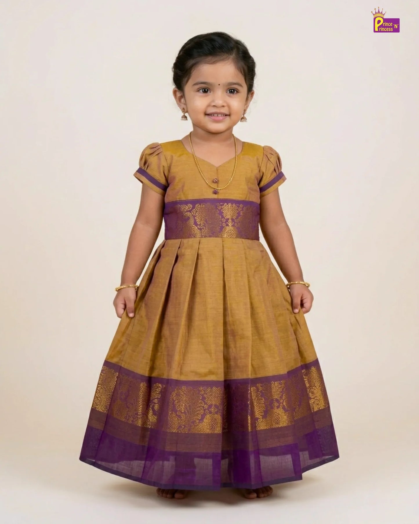 Child wearing a mustard yellow and purple traditional dress on a beige background