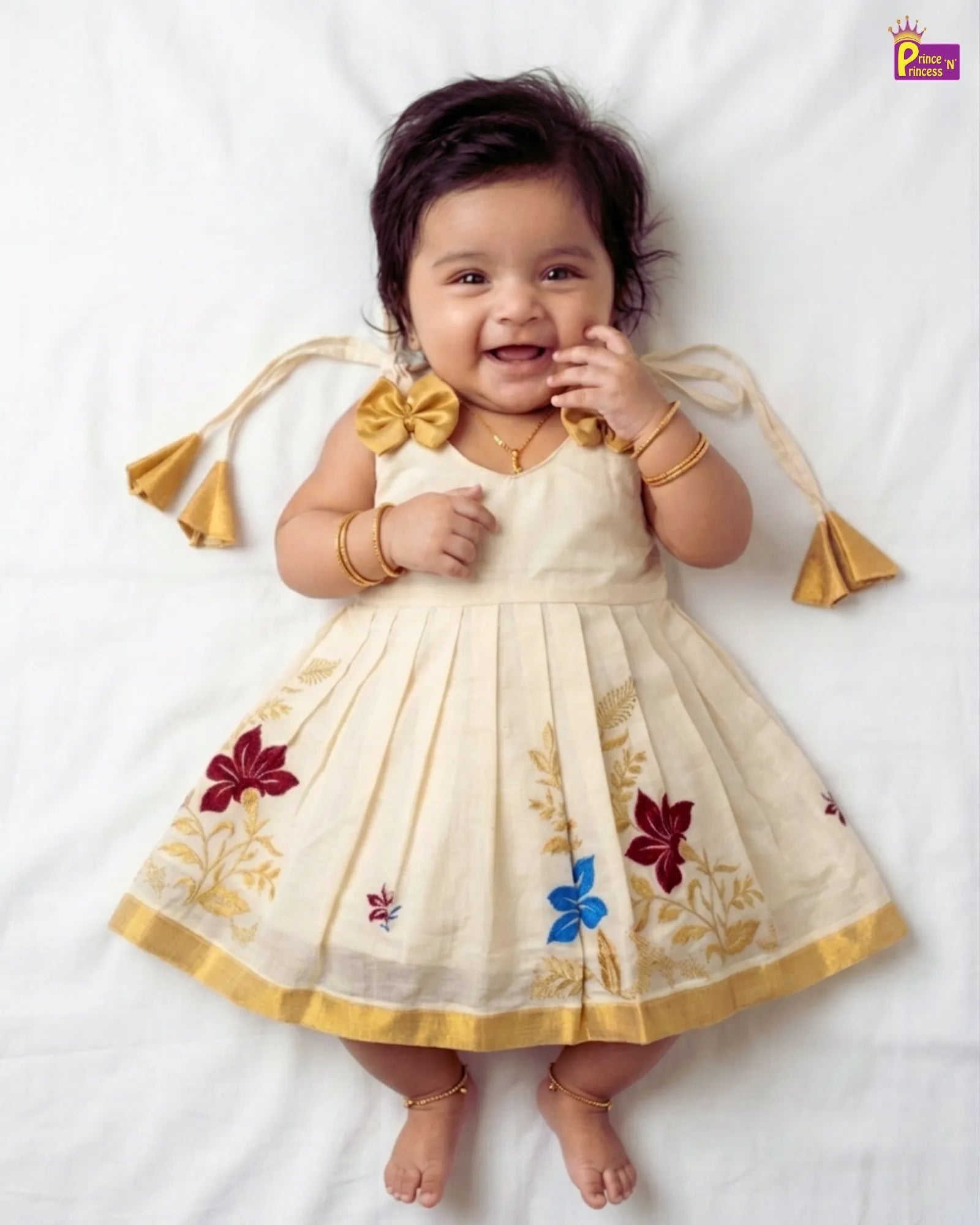 Baby wearing a traditional outfit with floral patterns on a white background