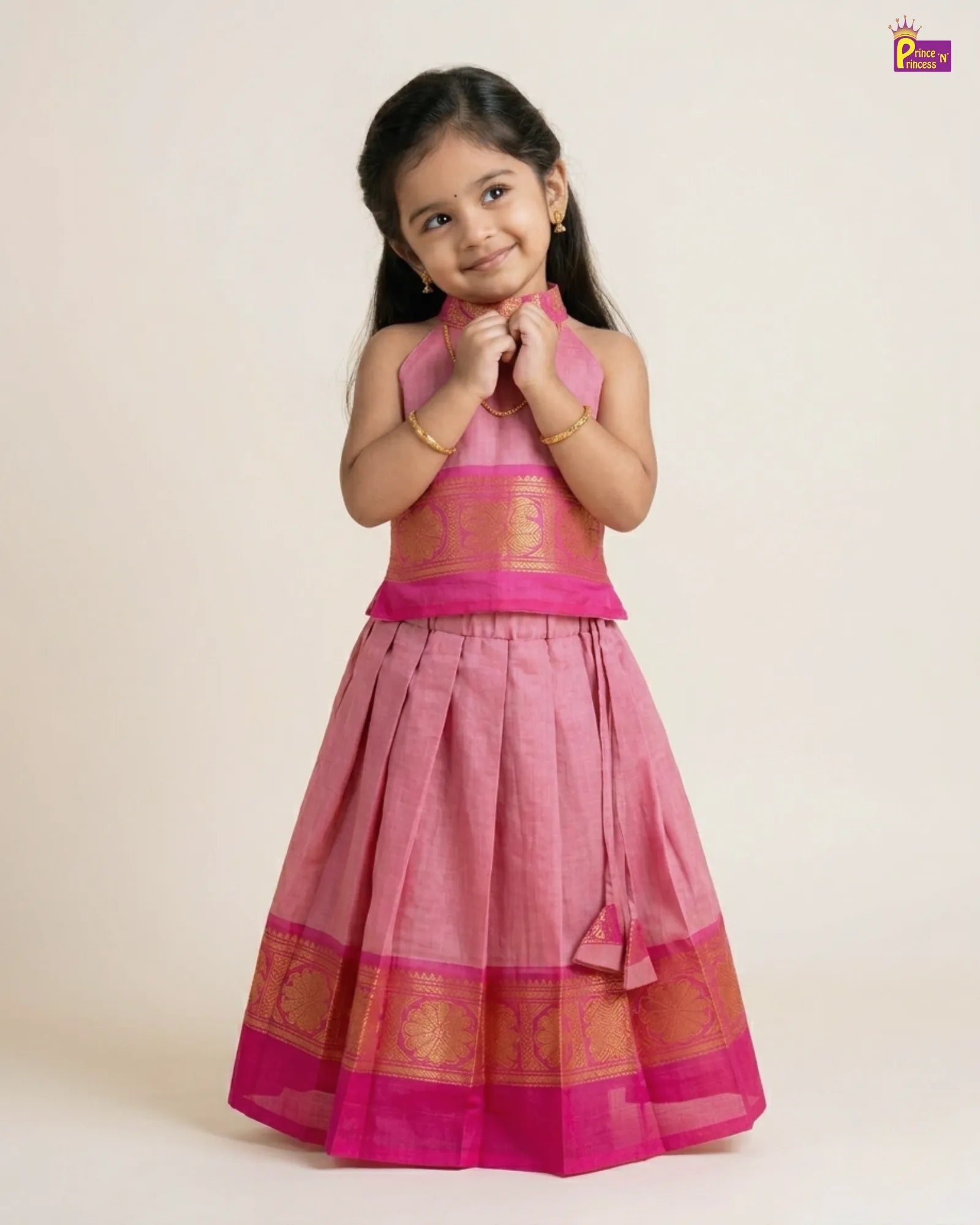 Young girl wearing a pink traditional outfit with gold accents on a white background