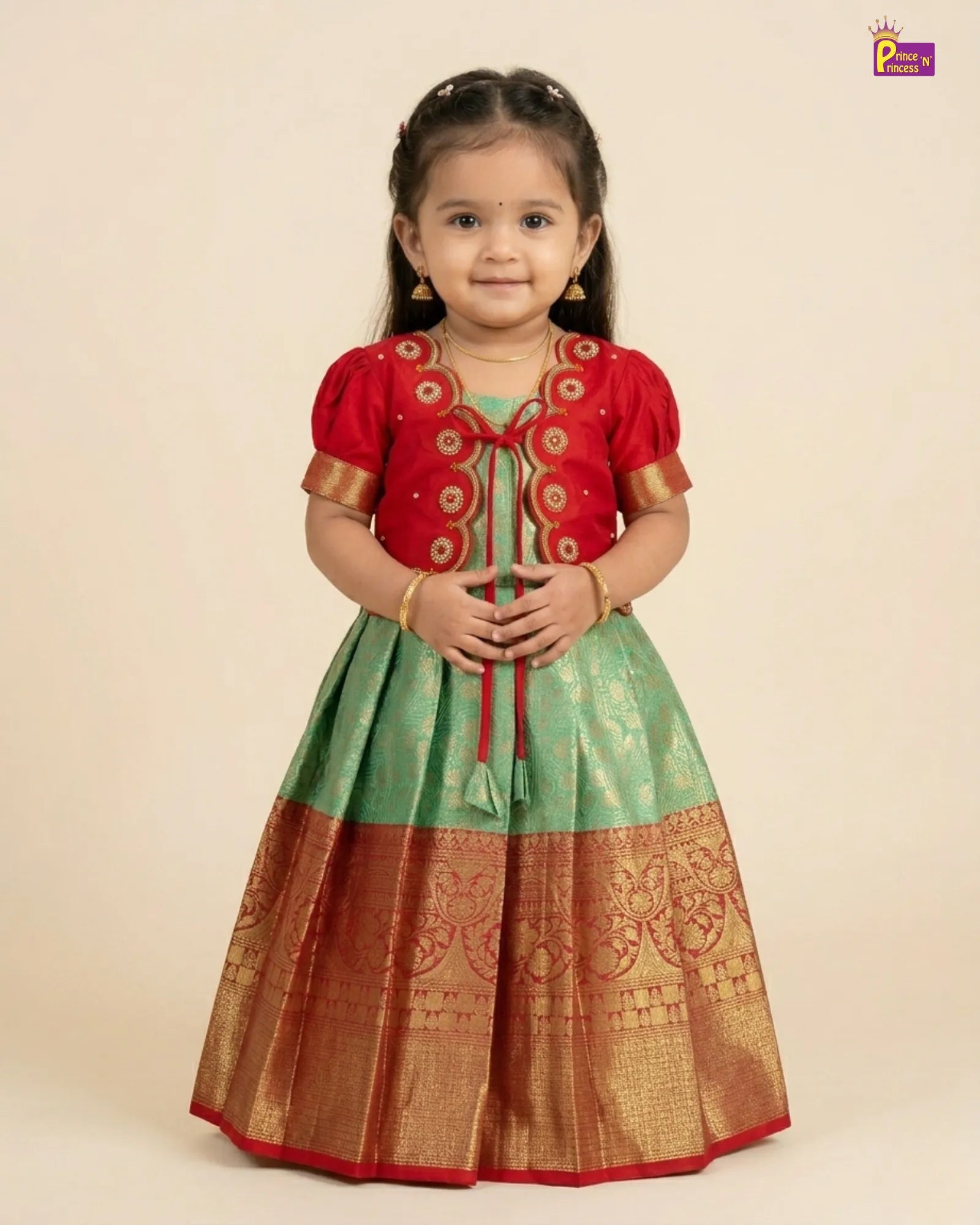 Young girl wearing a traditional red, green, and gold outfit on a beige background