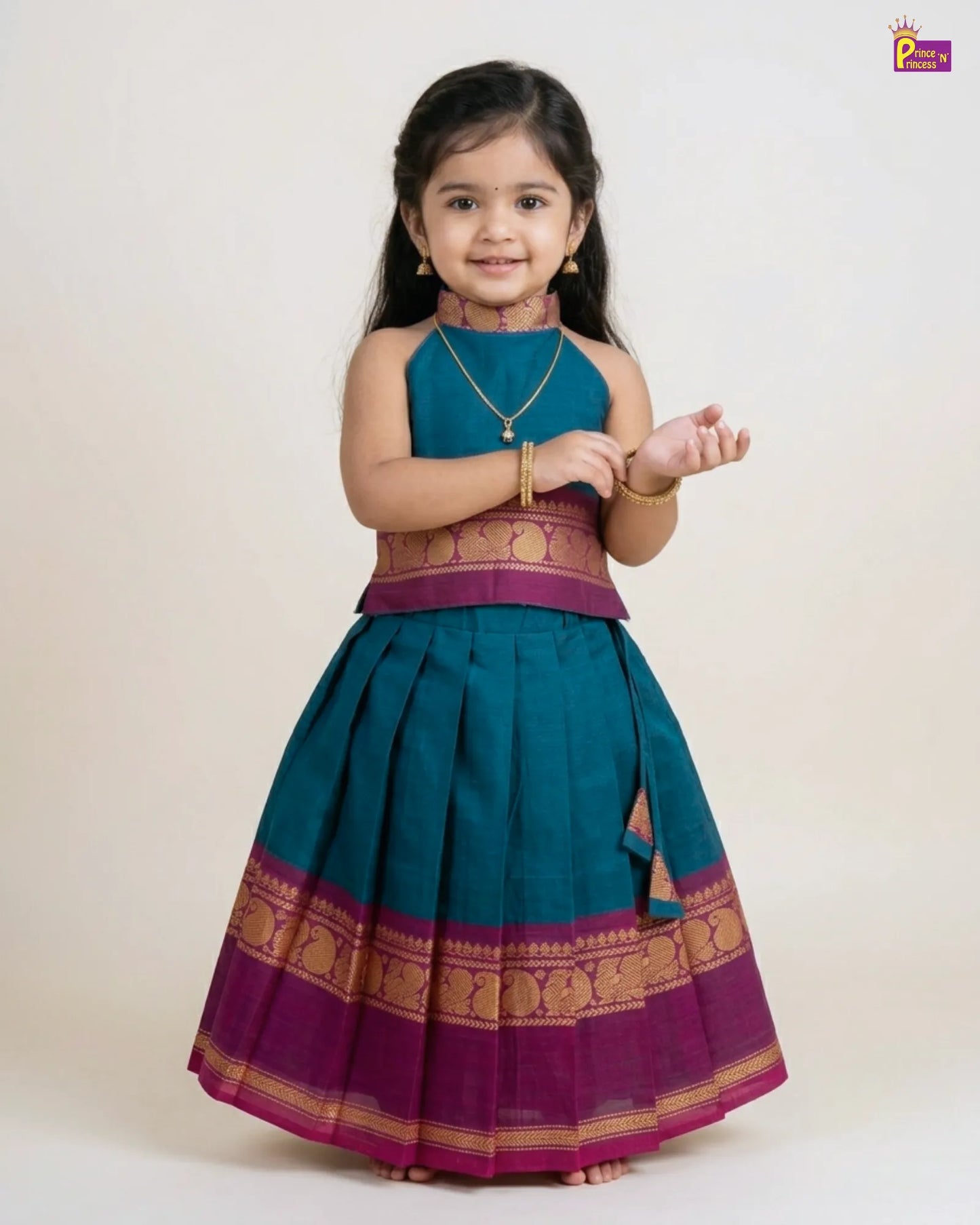Young girl wearing a traditional teal and purple outfit with gold accents on a white background