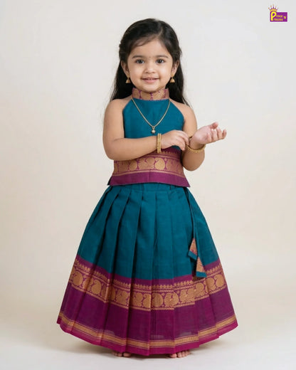 Young girl wearing a traditional teal and purple outfit with gold accents on a white background