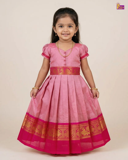 Young girl wearing a pink traditional dress with gold accents on a beige background