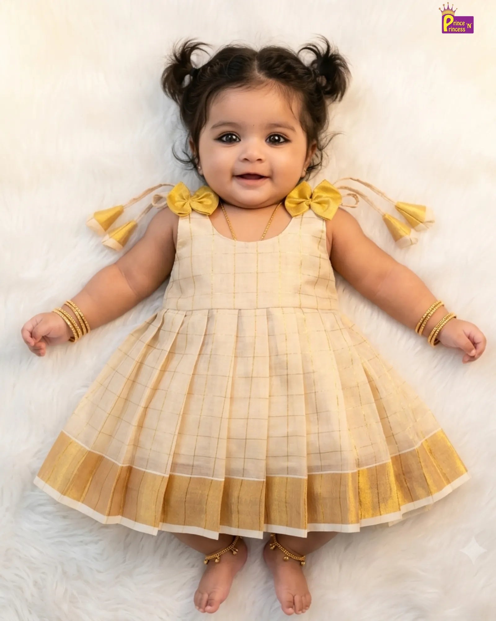 Baby wearing a yellow and white checkered dress with bow details on a light background