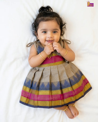 Baby wearing a colorful traditional dress on a white background