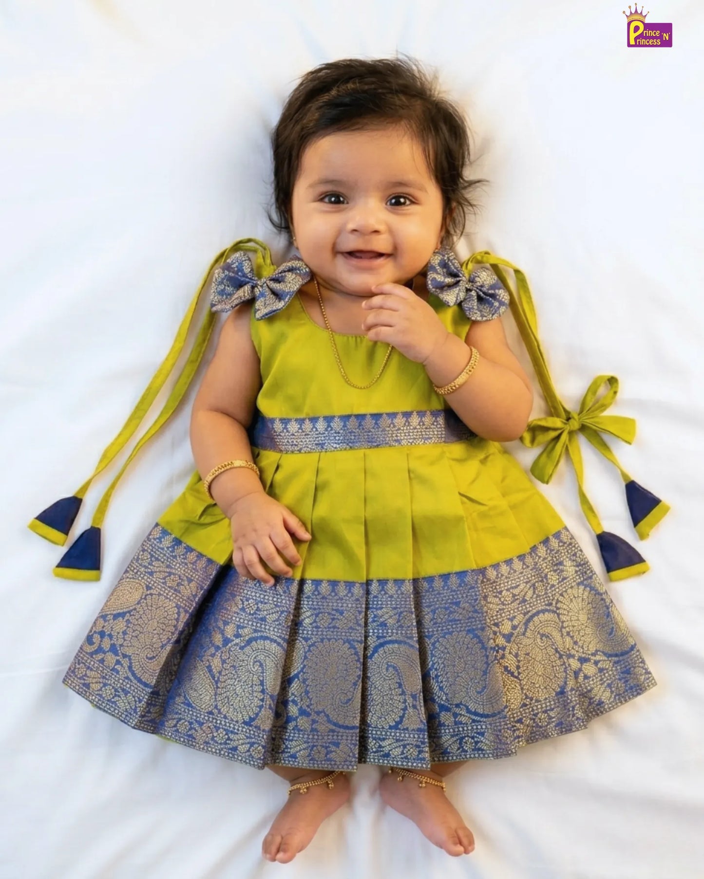 Baby wearing a pink top and patterned skirt on a white background