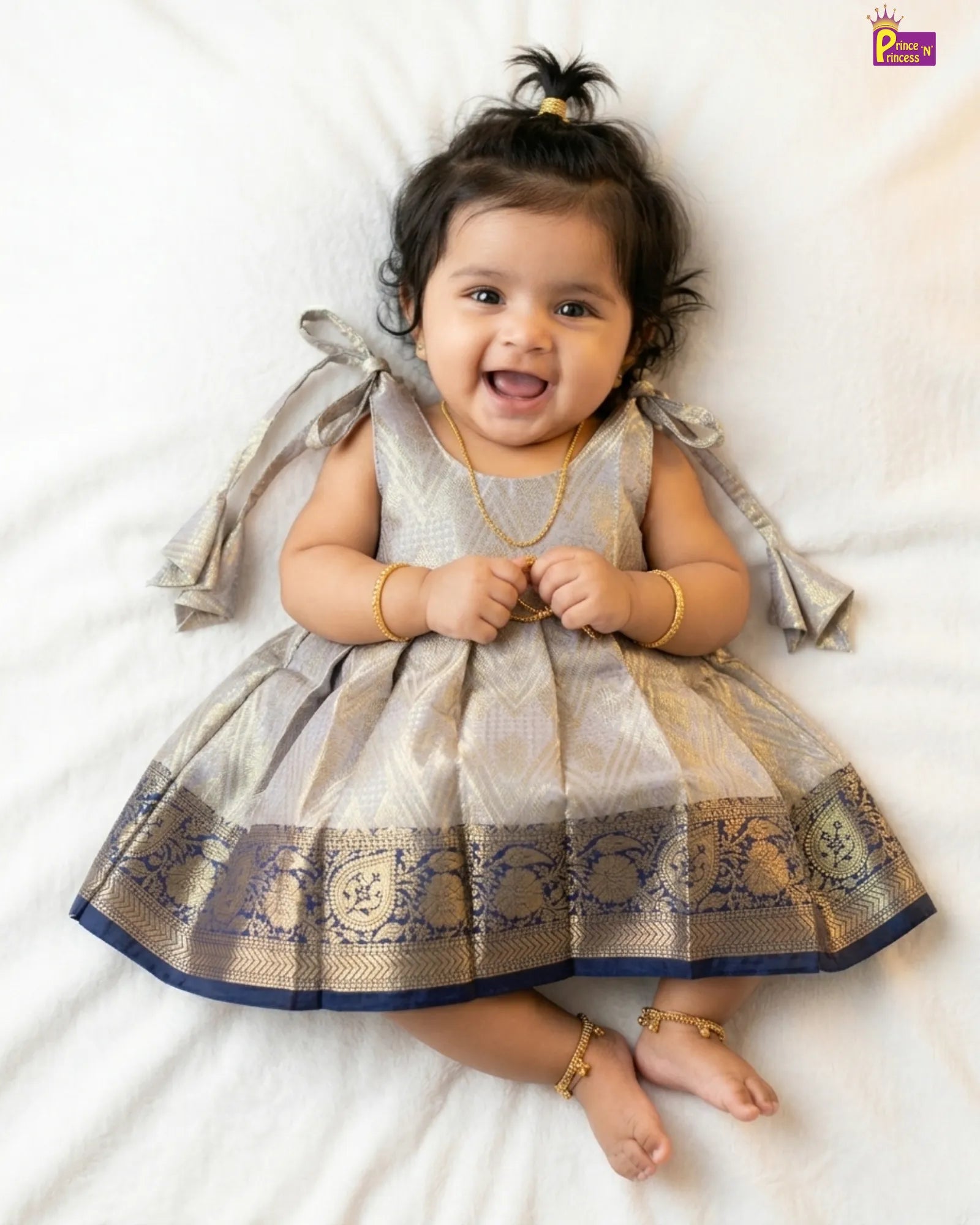 Baby wearing a traditional outfit with decorative patterns on a white background