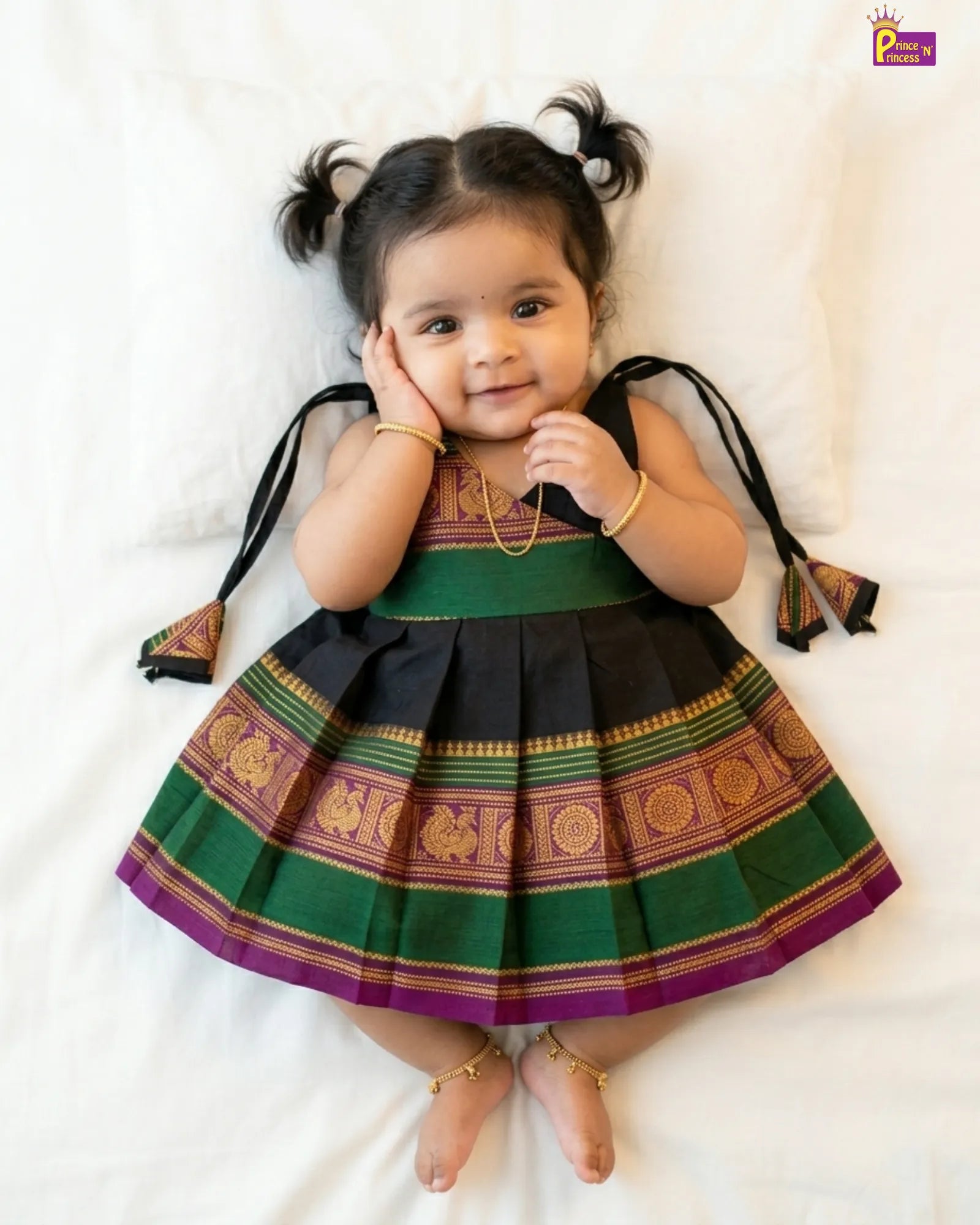 Child wearing a traditional outfit with green and black colors on a white background