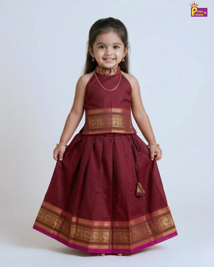 Young girl wearing a traditional maroon dress with gold accents on a white background