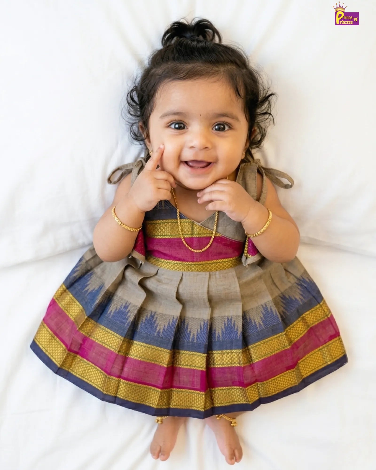 Child wearing a traditional outfit with colorful patterns on a white background