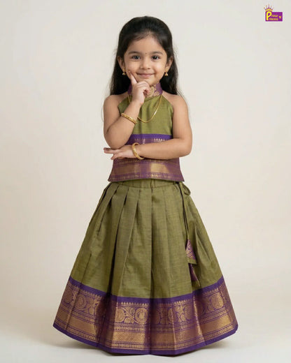 Young girl wearing a green and purple traditional outfit on a white background