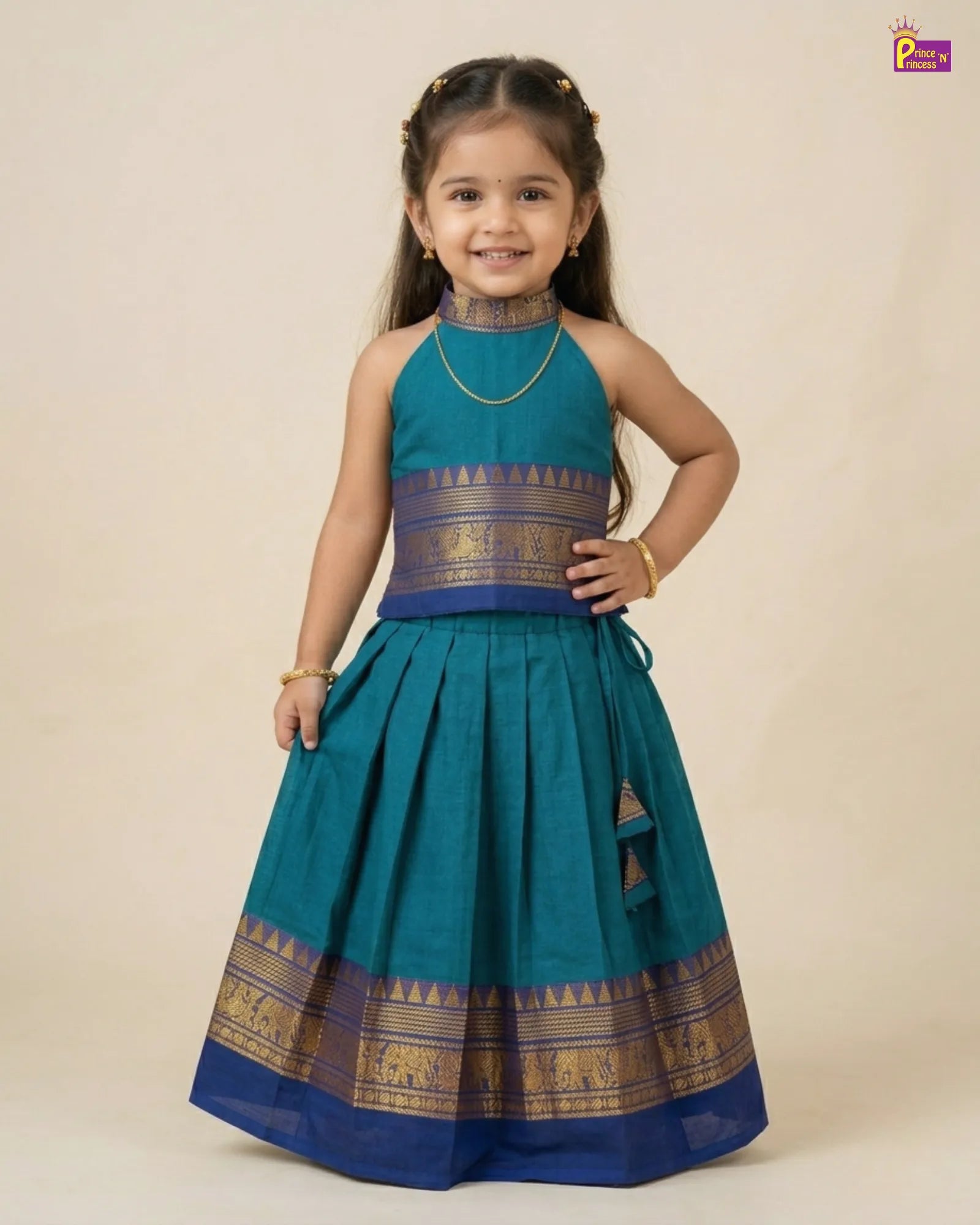 Young girl wearing a traditional teal and blue dress with gold accents on a beige background