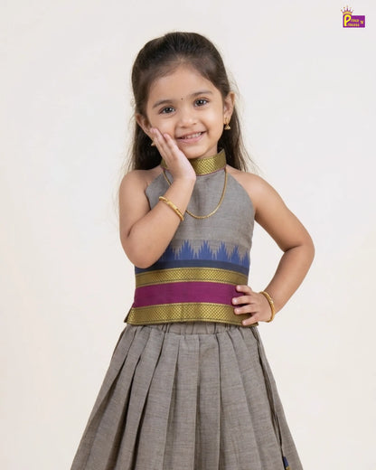 Young girl wearing a traditional outfit with a gray and purple top on a white background