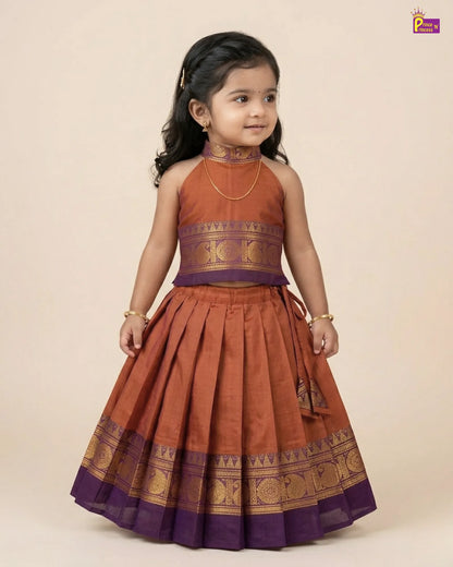 Young girl wearing a traditional orange and purple dress on a beige background