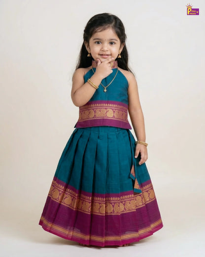 Young girl wearing a traditional outfit with a green and purple dress on a white background