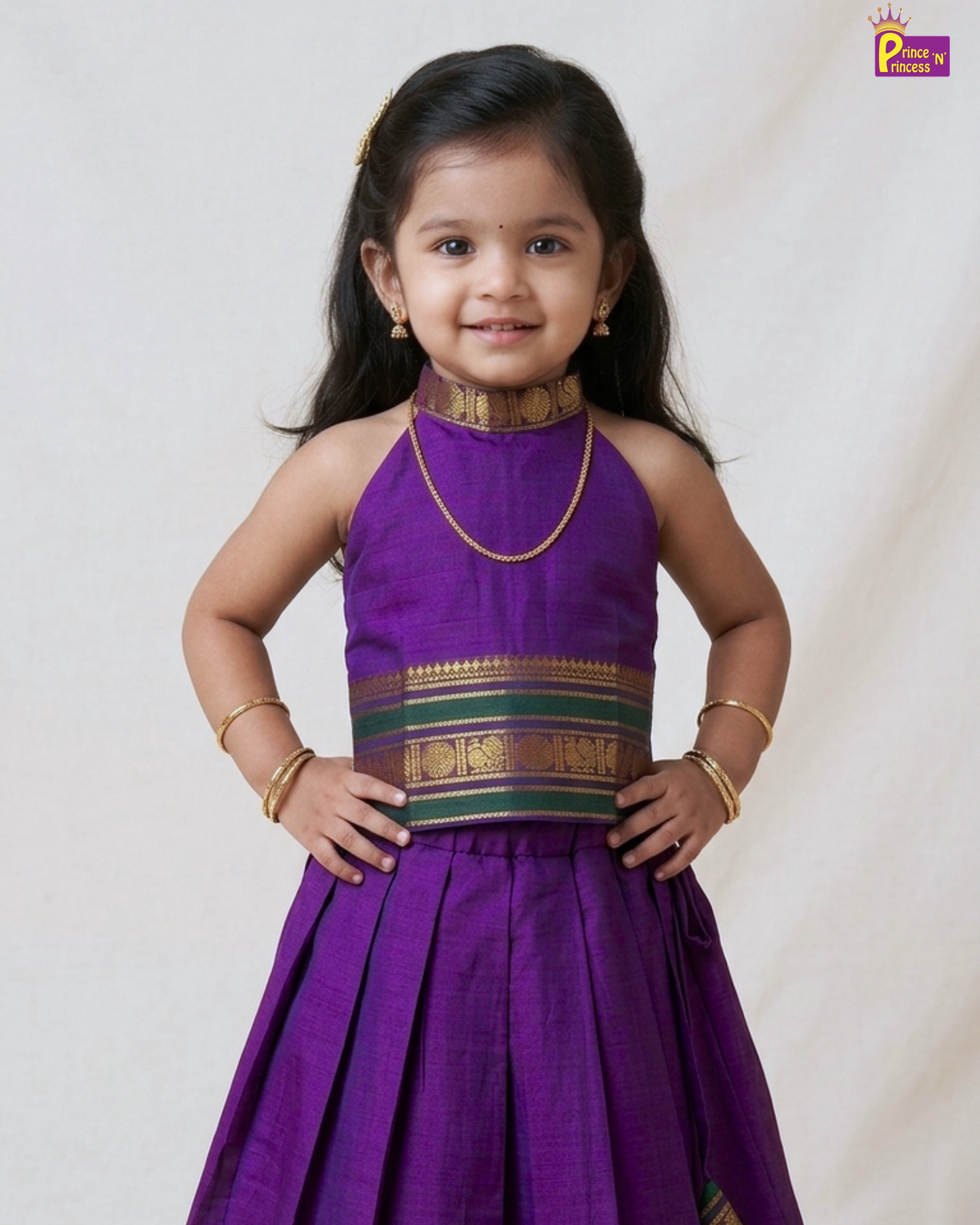Young girl wearing a purple traditional outfit with gold and green accents on a white background