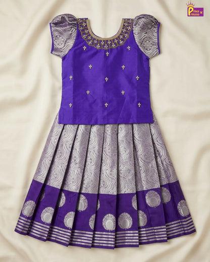 Purple and gray traditional dress with intricate patterns on a beige fabric background