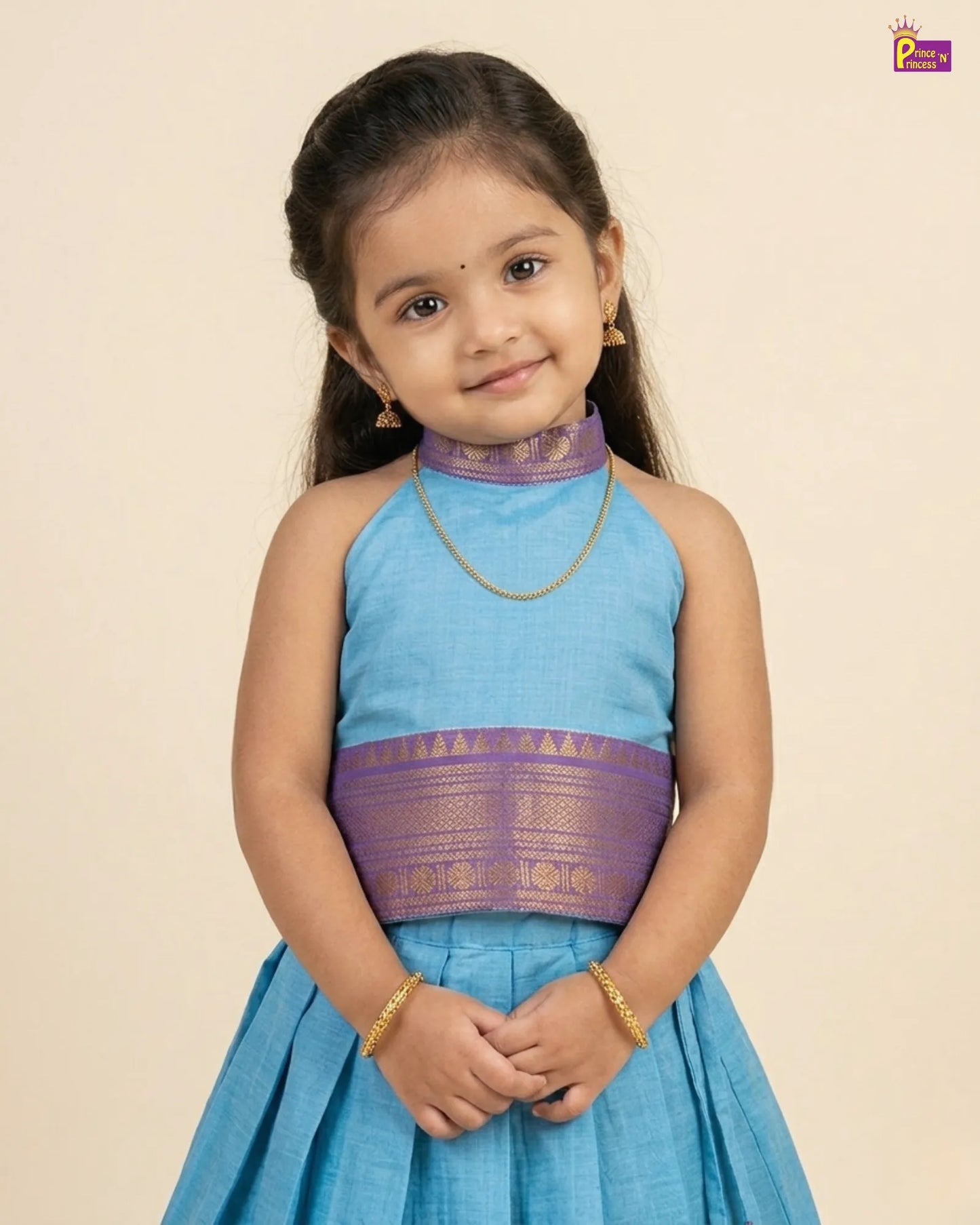 Young girl wearing a blue and purple traditional outfit on a beige background