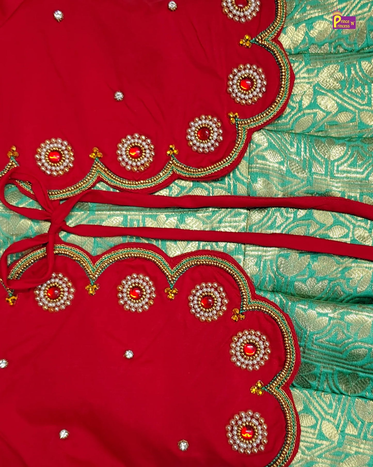 Close-up of a red and green saree with intricate embroidery