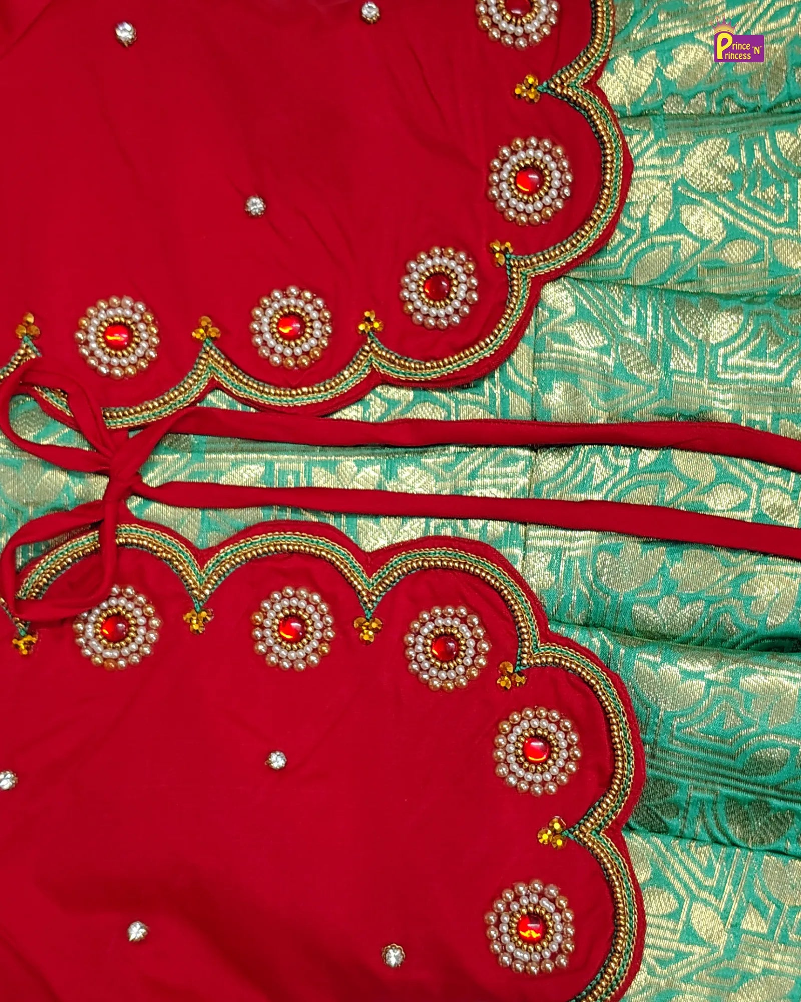 Close-up of a red and green saree with intricate embroidery