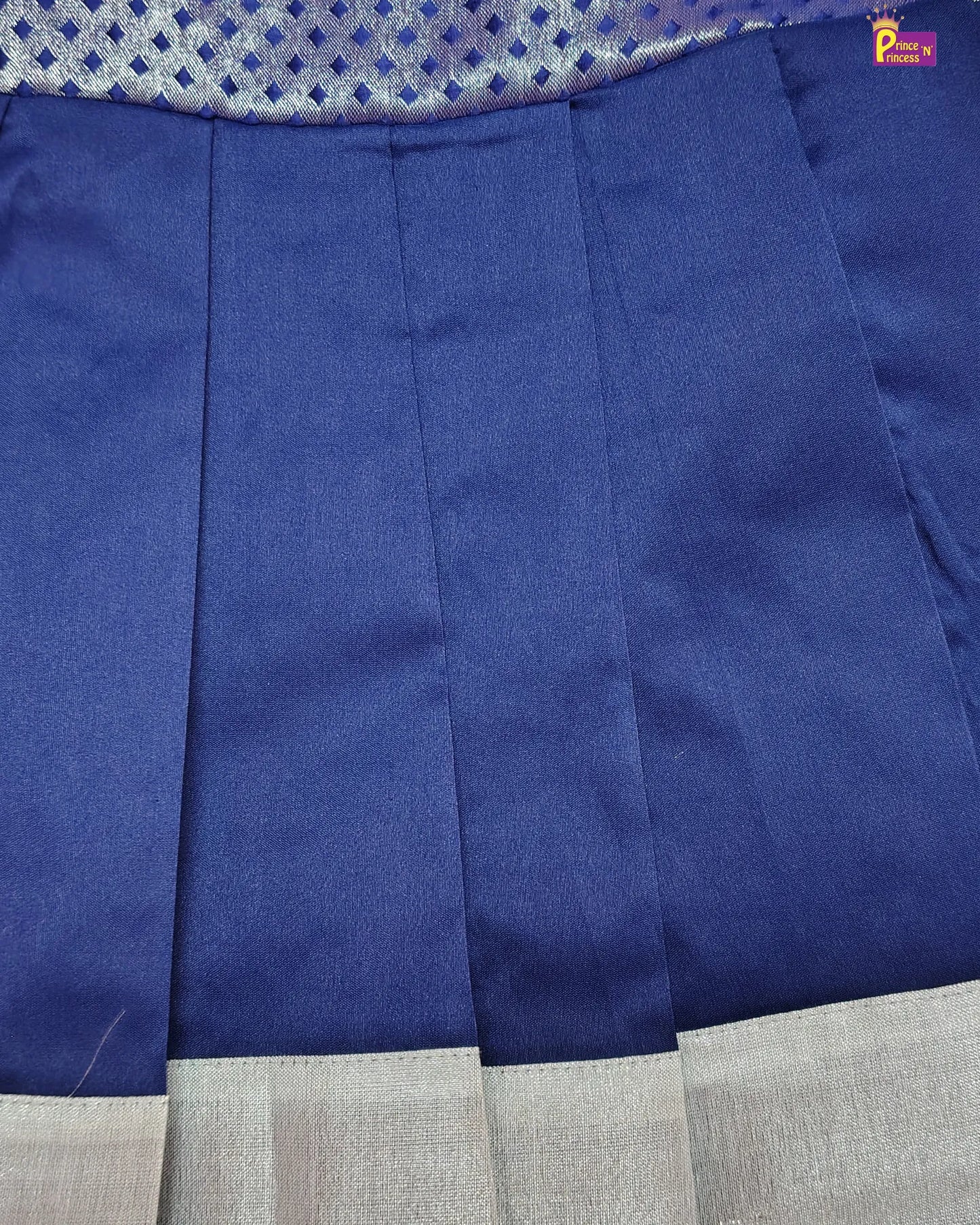 Close-up of a blue fabric with a gray border, featuring a brand logo in the corner.