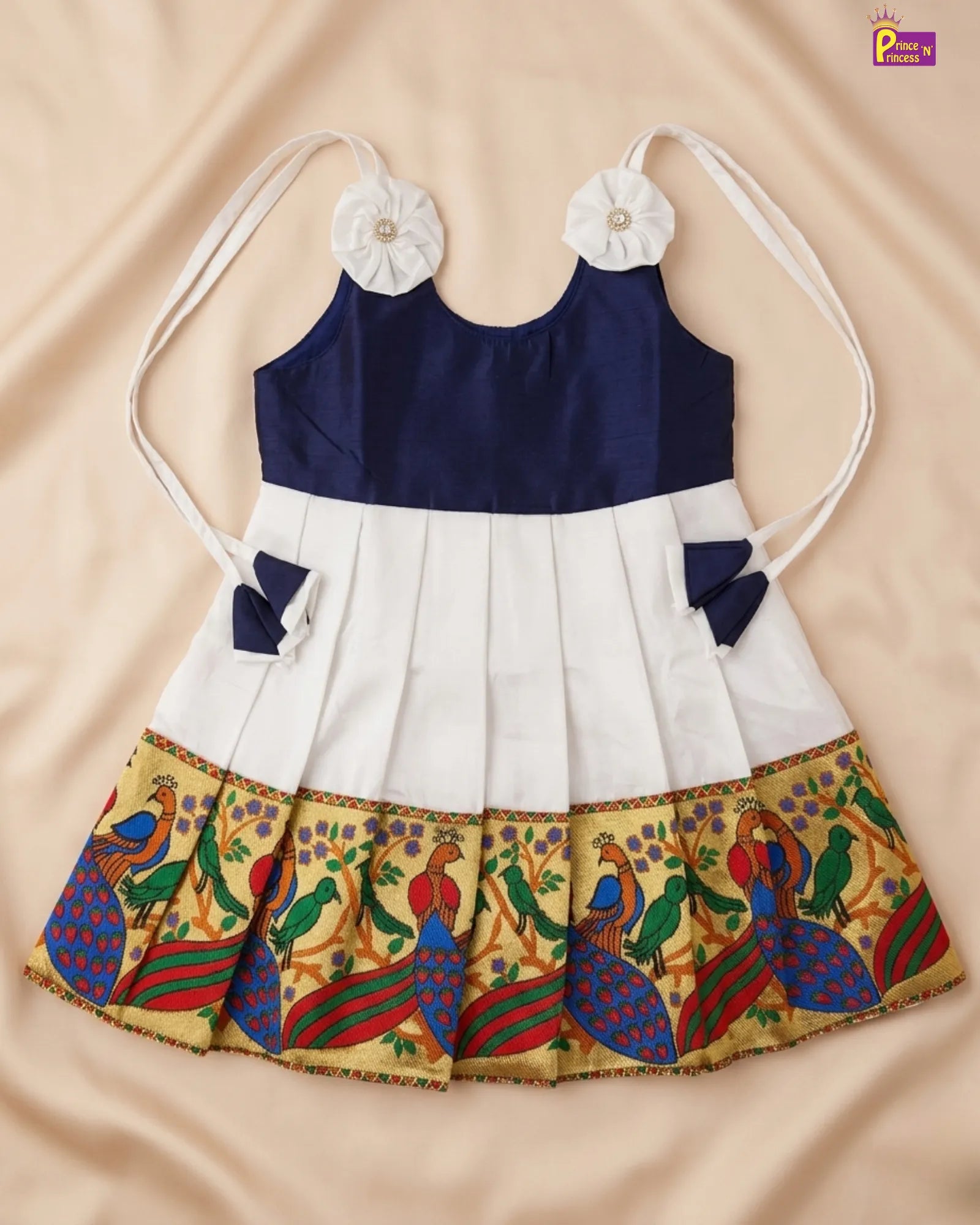 Children's dress with floral straps and colorful skirt on a beige background
