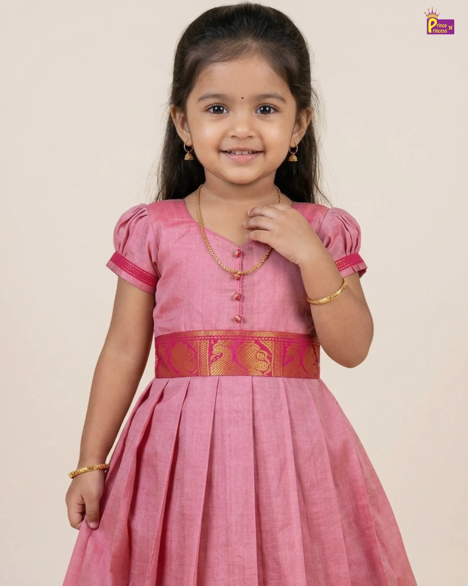 Young girl wearing a pink traditional dress with a gold belt on a beige background