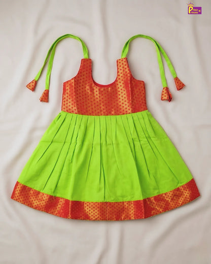Green and orange dress with tassels on a white background