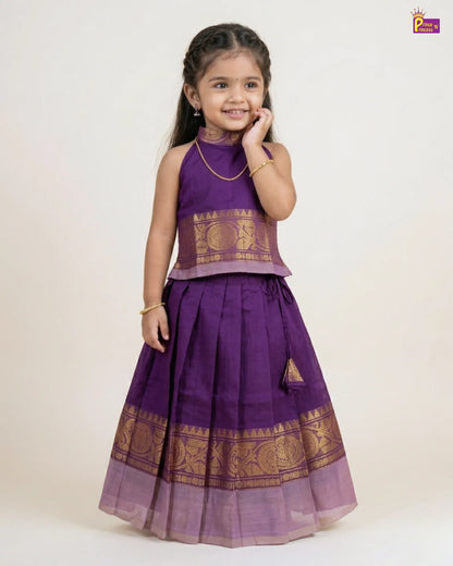Young girl wearing a purple traditional outfit with gold patterns on a white background
