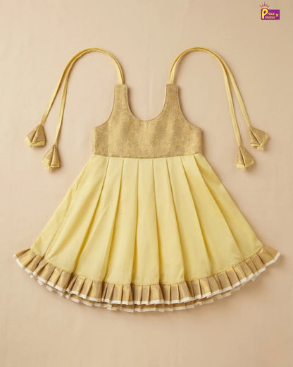 Yellow dress with pleated skirt on a beige background