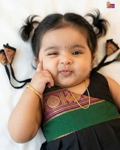 Child wearing a traditional outfit with decorative elements on a white background